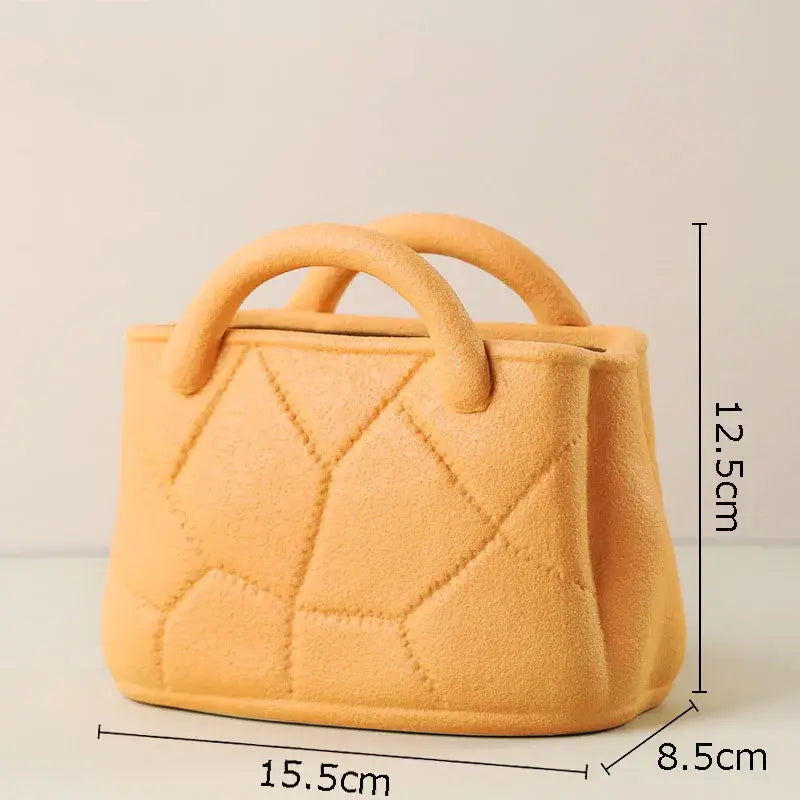 A miniature peach-colored felt handbag with quilted diamond pattern and rounded handles for decorbites handwoven ceramic vase decor
