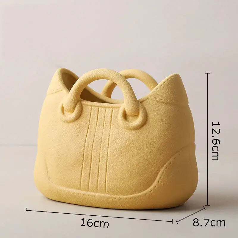 Pale yellow ceramic vase shaped like a handbag with stitched detailing by decorbites handwoven ceramic vase collection