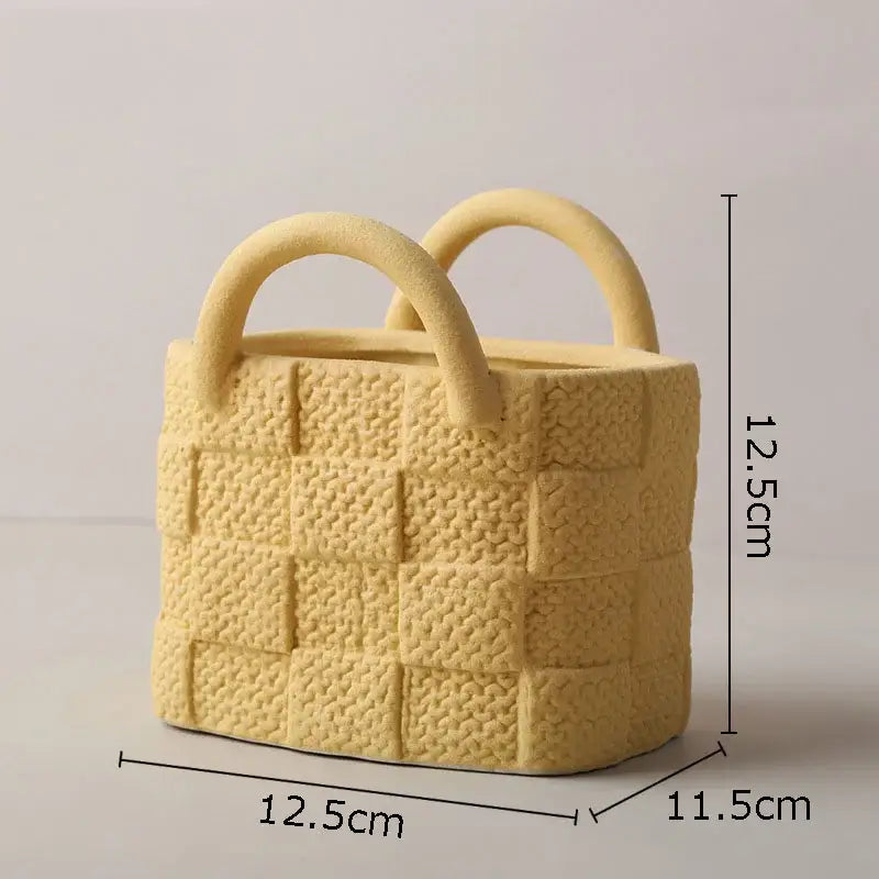 A pale yellow decorbites handwoven ceramic vase basket planter with woven texture and two rounded handles for decor