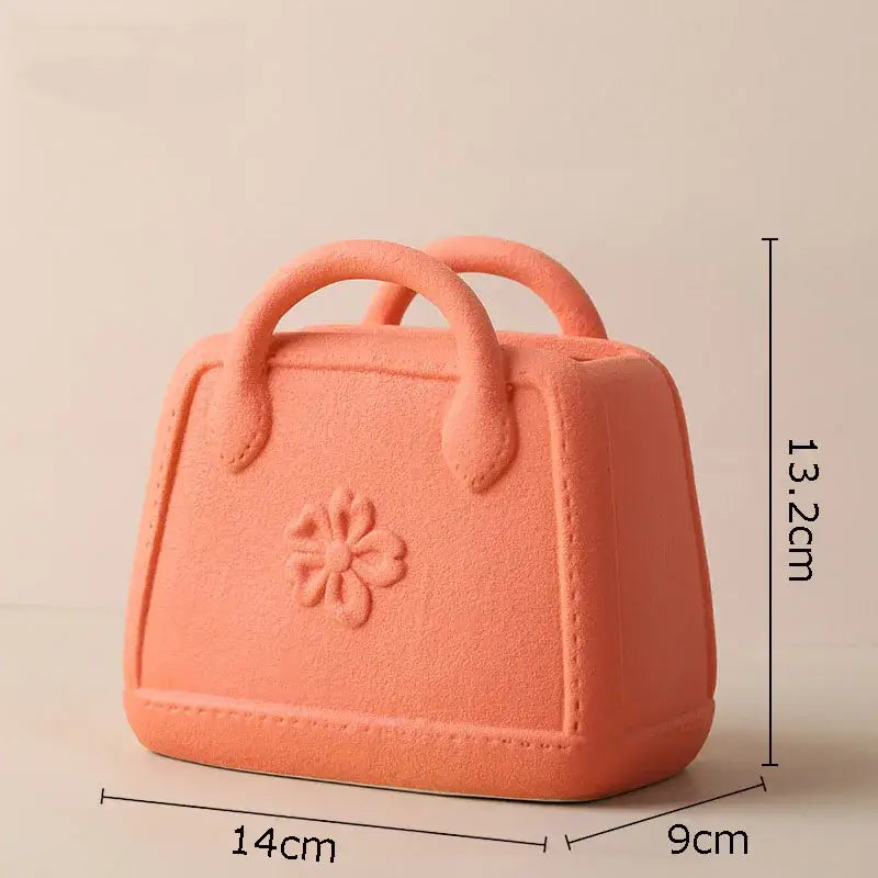 Coralb-colored decorbites handwoven ceramic vase shaped like a handbag with floral embossing and stitched detailing