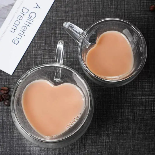 Heart glass mug set featuring double-walled clear glass mugs with heart shapes and clear handles filled with creamy beverage