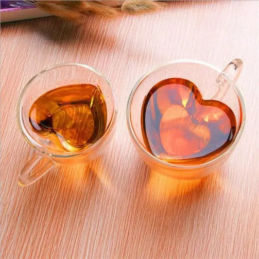 Two clear amber liquid-filled heart shaped double wall glass mugs in a kitchen drinkware set