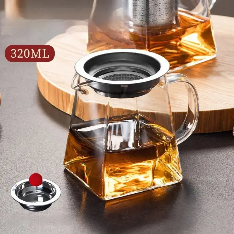 Clear glass fair cup tea set with silver metal infuser and lid filled with amber kung fu tea for dining room use