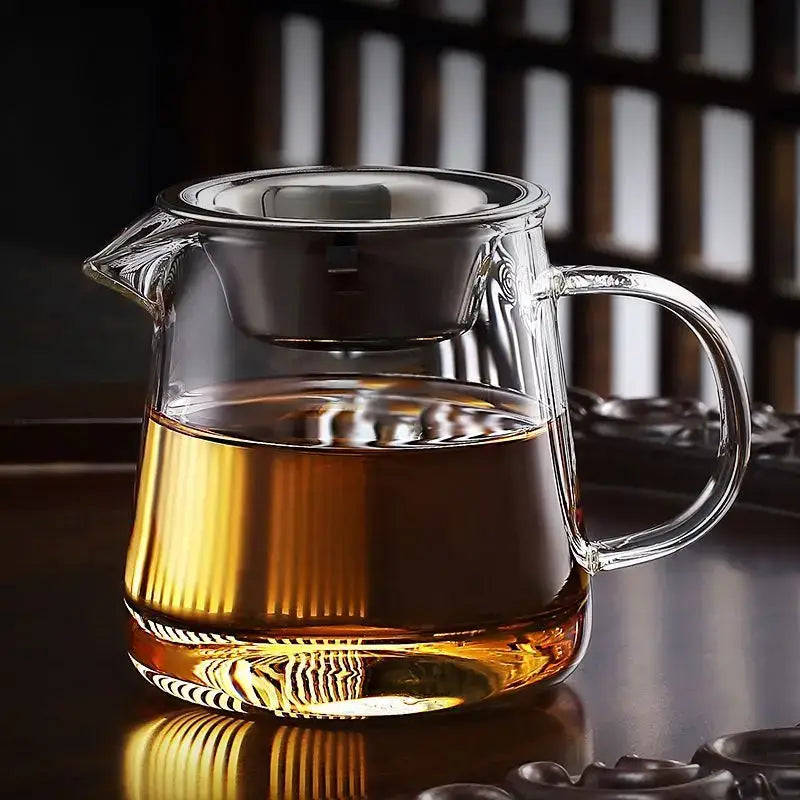 Heat resistant glass kung fu tea set fair cup with built-in strainer and ribbed base filled with amber tea
