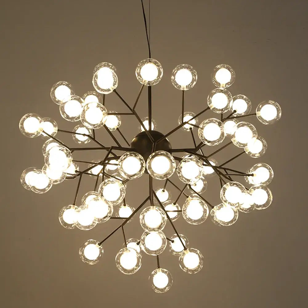 A modern decorbites heracleum firefly gold glass ball chandelier with dark metal frame and clear globe bulbs for dining room