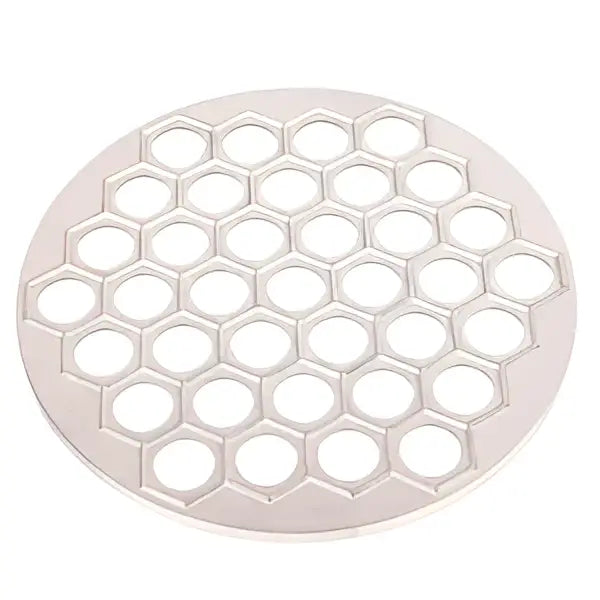 Silver honeycomb-patterned metal trivet paired with a black aluminum dumpling maker mold kitchen tool for dumpling making