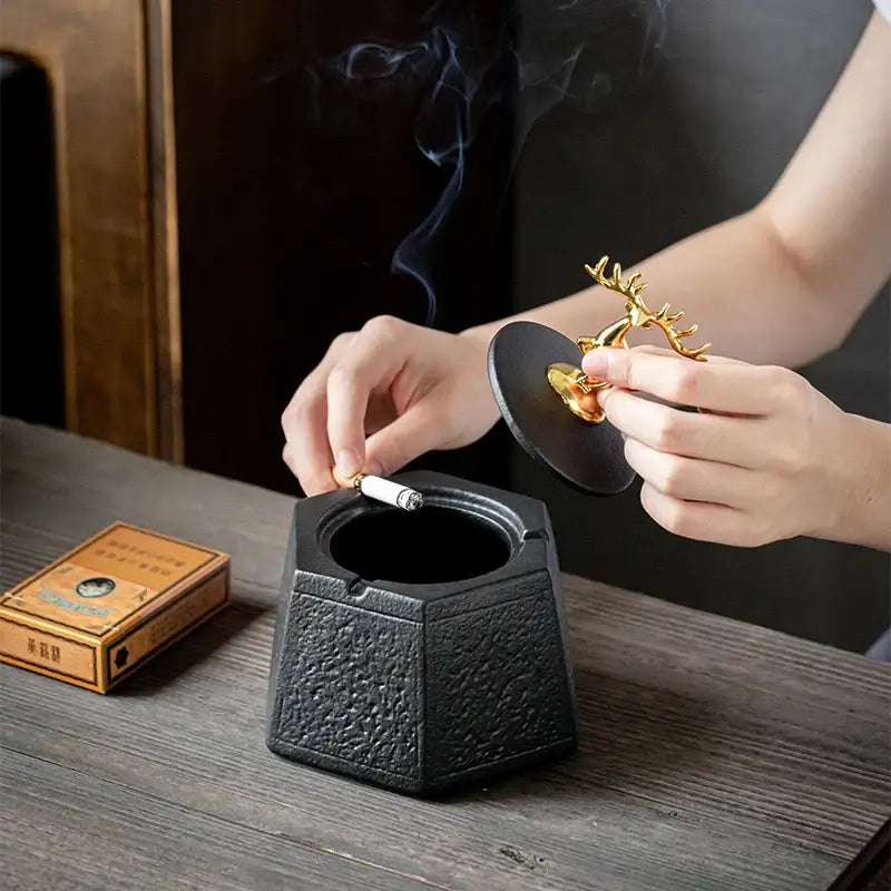 Hexagonal black pottery ashtray with textured surface and gold deer lid for living room decorbites black pottery