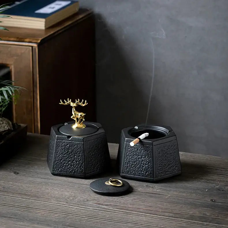 Hexagonal black pottery ashtray with gold deer lid and lit cigarette from decorbites black pottery for living room decor