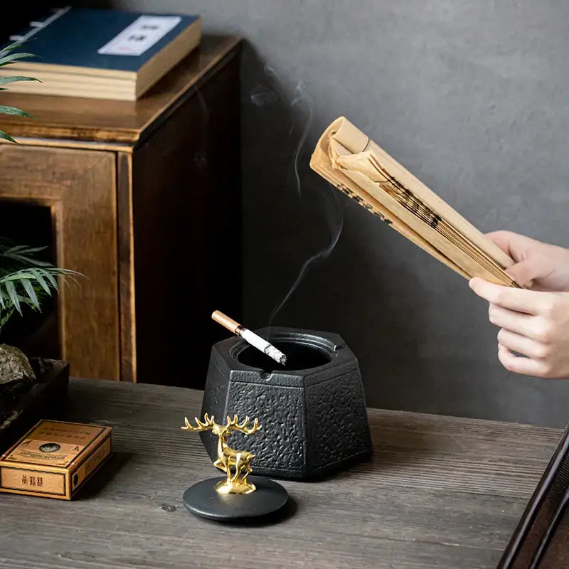 Black pottery ashtray by decorbites featuring a hexagonal textured design with a gold deer figurine for living room decor