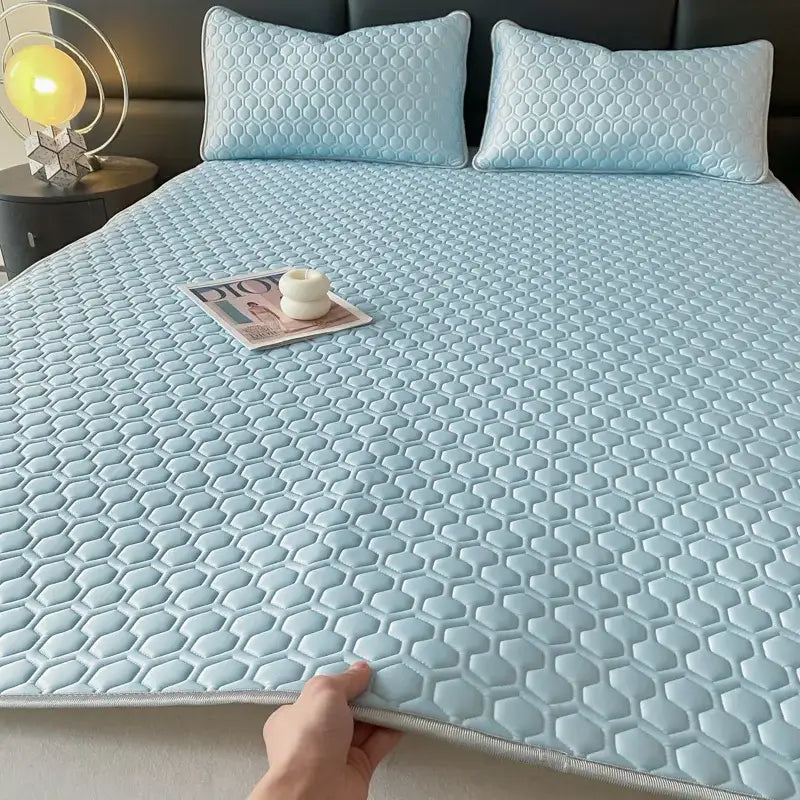 Light blue hexagonal-patterned cooling mattress pad complementing pink and gray quilted bed sheet set for bedroom use