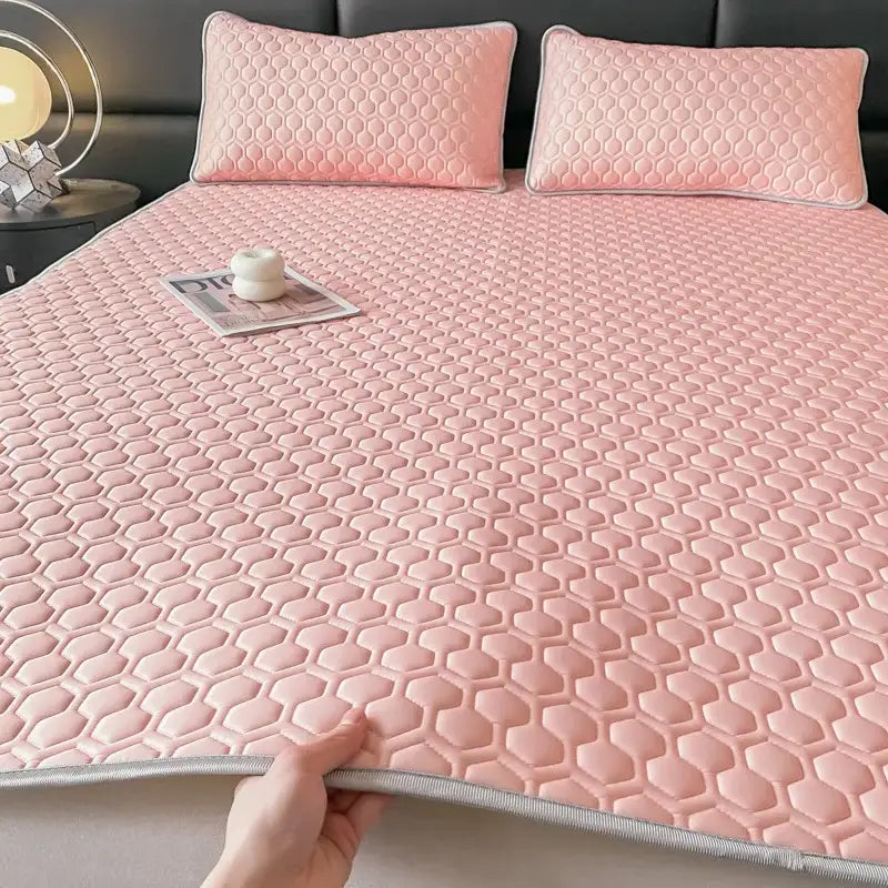 Pink hexagonal quilted bed sheet set with gray border designed as a cooling bedroom mat for comfort and style