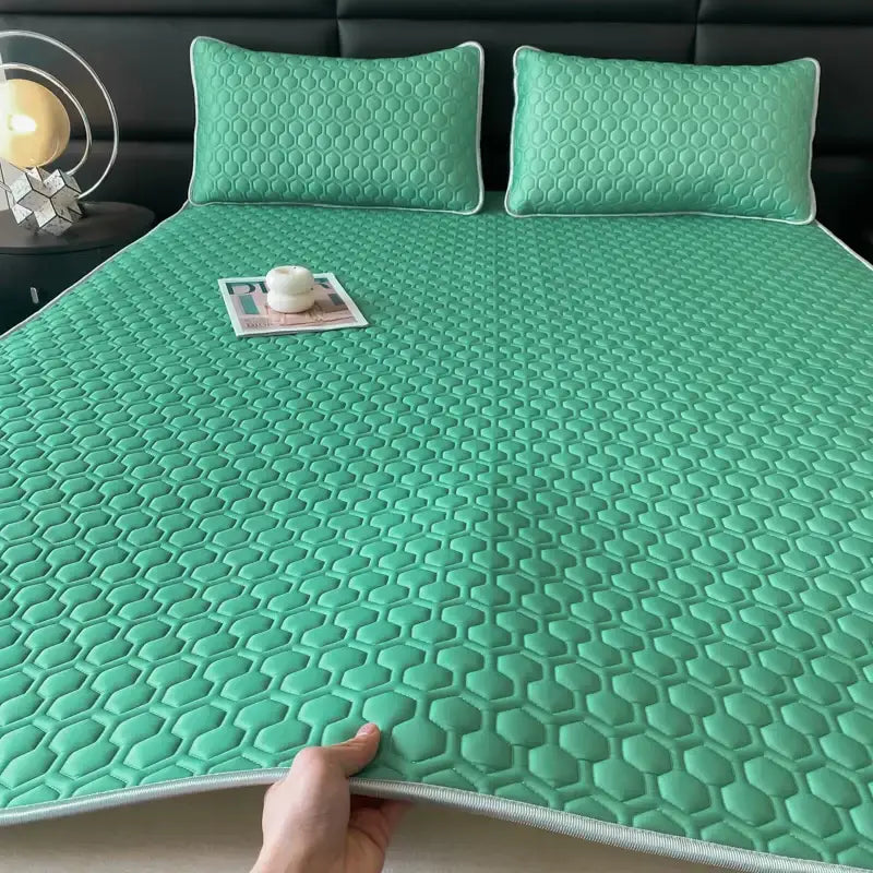 Teal hexagonal quilted bed pad with white piping complementing the pink and gray cooling bed sheet set bedroom mat