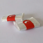 Two transparent plastic-wrapped high temp baking bags secured with red bands in a 20 piece kitchen tool set