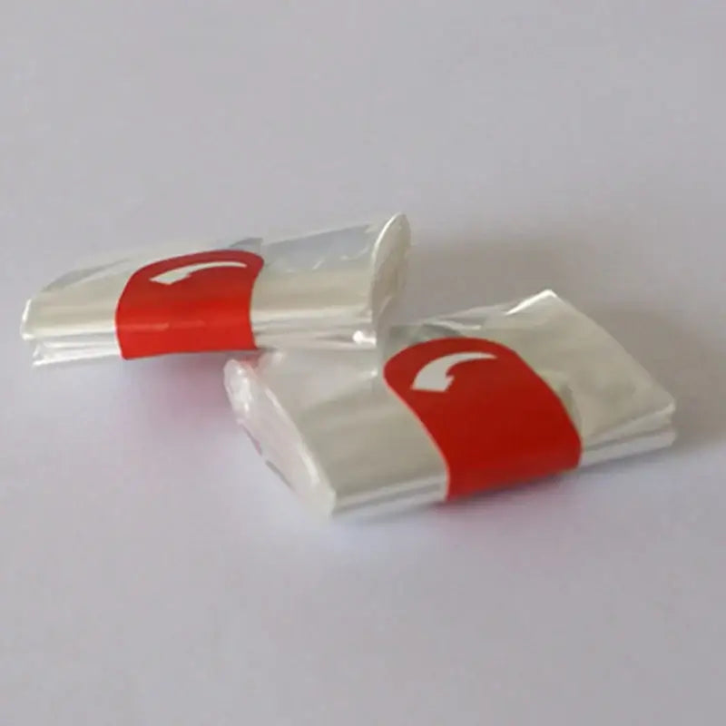 Two transparent plastic-wrapped high temp baking bags secured with red bands in a 20 piece kitchen tool set