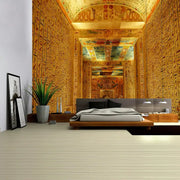 Modern platform bed with sleek gray upholstered headboard and wooden frame in bedroom with egyptian pharaoh mural tapestry