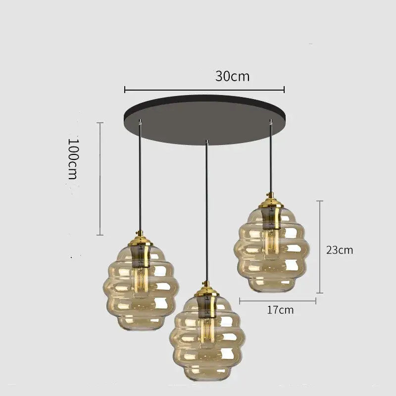 Modern three-light pendant light with amber honeycomb glass shades and brass accents for kitchen dining decorbites colorful glass