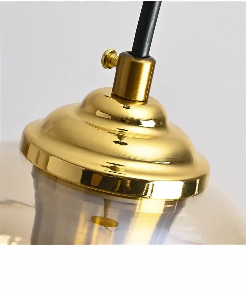 Gold-toned metal lamp fixture with polished finish and black cord for honeycomb amber blue and gray glass pendant light decorbites colorful glass ball