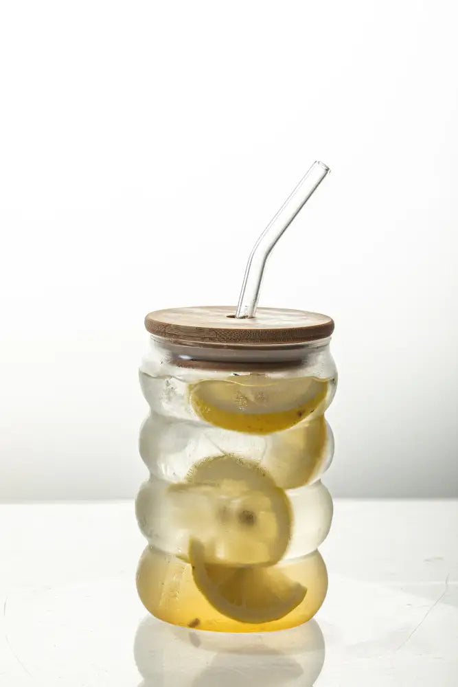 Clear glass creative glass cup with bamboo lid and curved straw filled with lemon slices in icy water decorbites creative glass