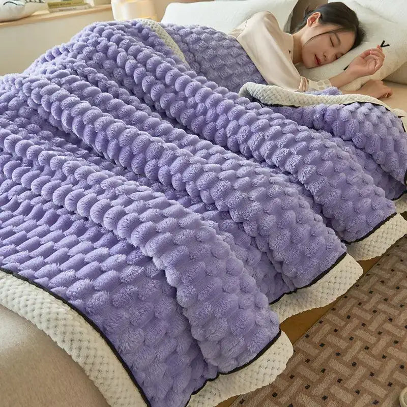 A plush lavender cozy coral fleece bed blanket with honeycomb textured teal and cream decorbites cozy coral trim