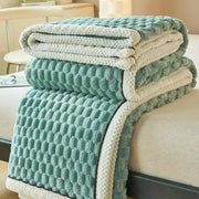 Stacked plush cozy coral fleece bed blankets with honeycomb textured pattern in soft teal and cream for decorbites cozy coral