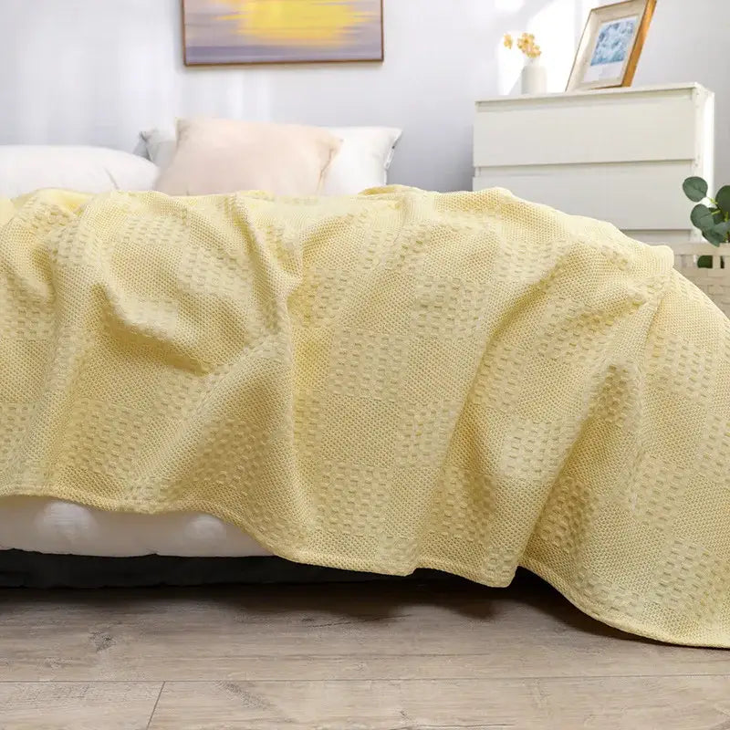 Soft pale yellow honeycomb waffle cotton throw blanket with textured waffle pattern for bedroom decor by decorbites