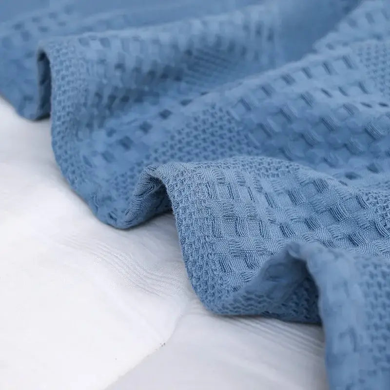 A soft light blue honeycomb waffle cotton blanket with textured grid pattern ideal for bedroom decorbites decor