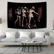 Black and sepia horror movie character tapestry featuring three dancers in metallic outfits above a gray sofa decorbites