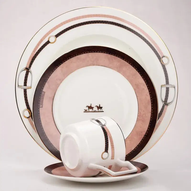 A white porcelain cup with pink and brown horsebit design and gold accents from the hermès decorbites bone china tableware set