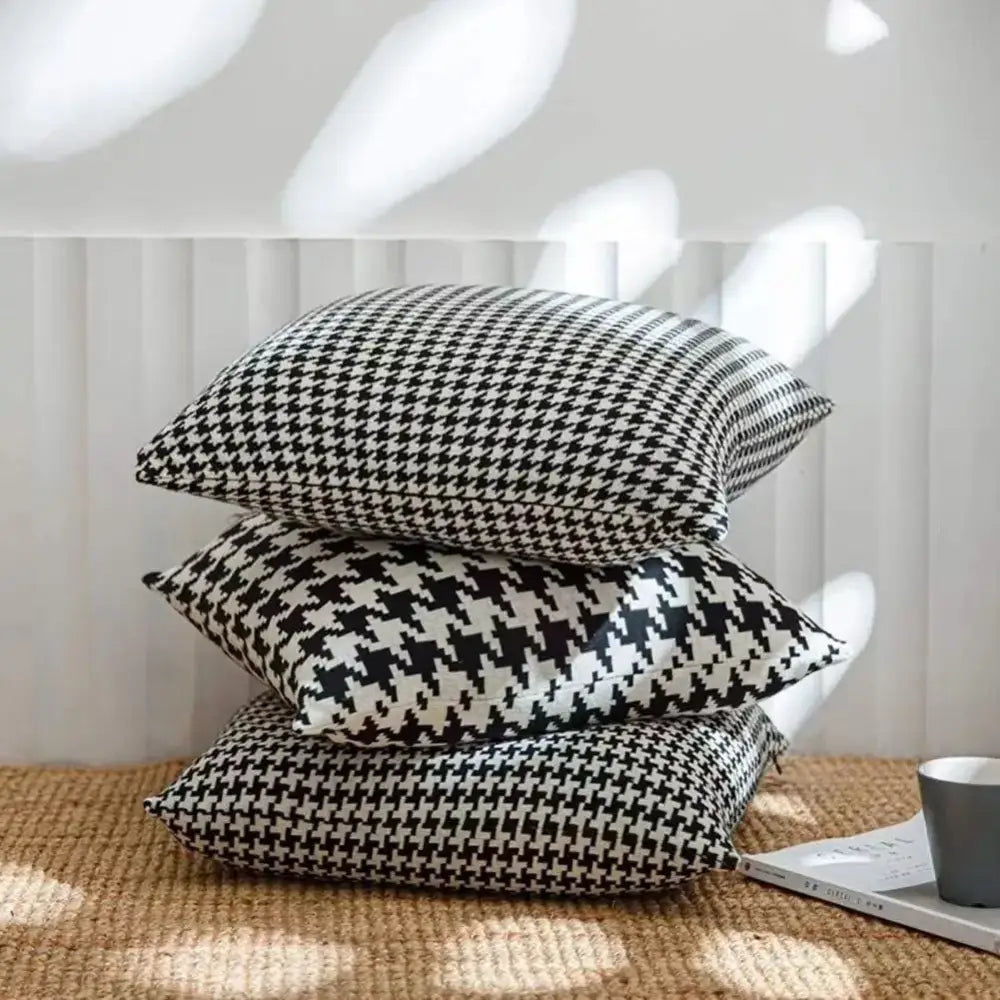 Stack of three black and white decorbites houndstooth plaid pillow covers for stylish living room decor