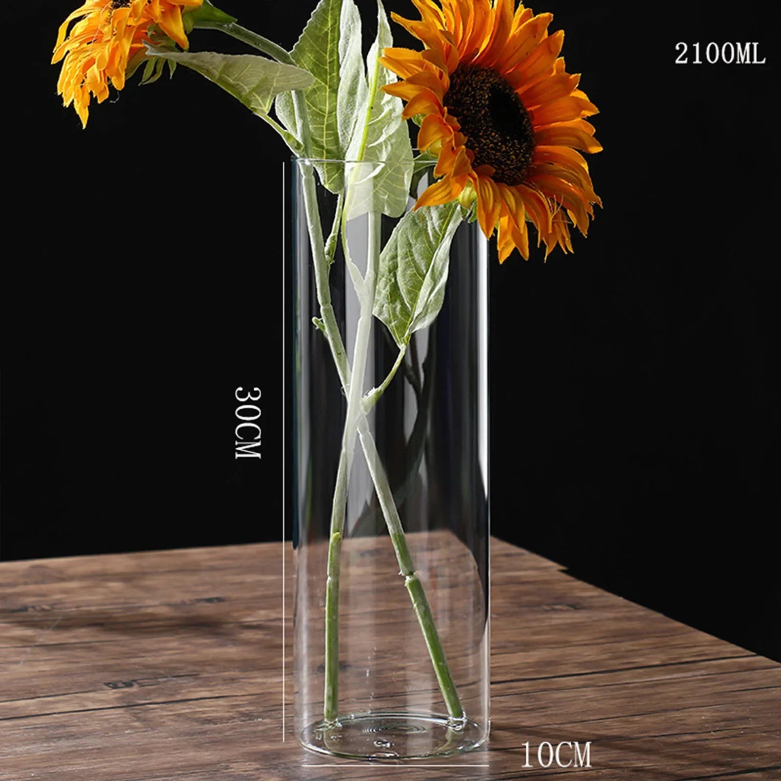Clear cylindrical glass vase 30cm tall 10cm wide holding vibrant orange sunflowers for desktop hydroponics plants