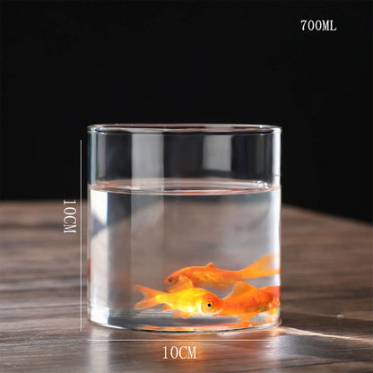 A clear glass cylinder planter vase with 10cm diameter holding water and two orange goldfish for desktop decor