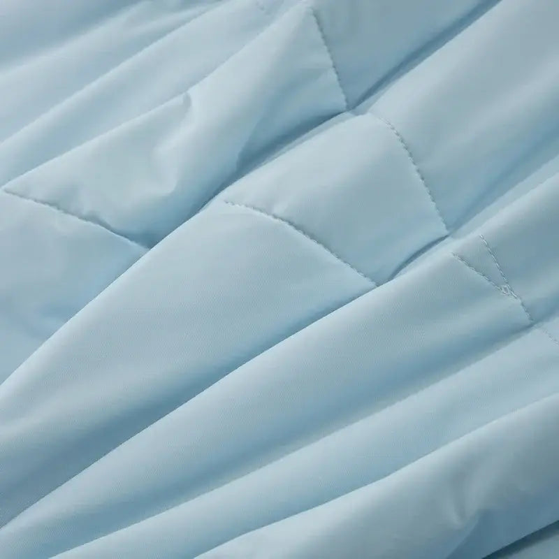 Light blue quilted ice silk cooling blanket with soft smooth texture and subtle stitching for bedroom comfort by decorbites