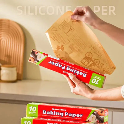 Illustrated grease-resistant baking paper in red and green packaging with 10-meter brown silicone-coated roll unrolling