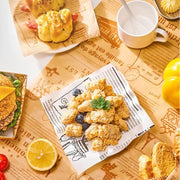 Golden crispy fried chicken served on white grease-resistant baking paper with black line art illustrations