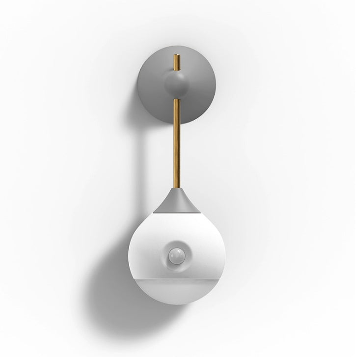 Modern white and gray wall sconce with brass accents.