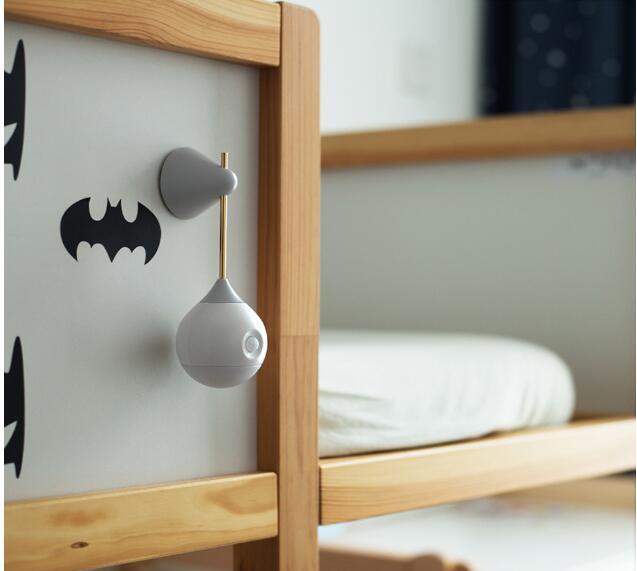 Batman-themed wooden bunk bed with gray hooks and white lightbulb-shaped nightlight.
