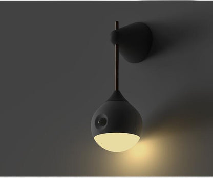 Modern black wall sconce with white ceramic shade and wooden pole.