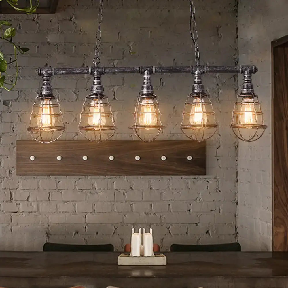 Industrial aged silver metal caged island light pendant with five clear glass cages and dark metal pipe frame for dining room