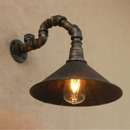 Decorbites™ farmhouse style antique brass wall sconce with dark rustic metal pipe arm and antique brass cone shade