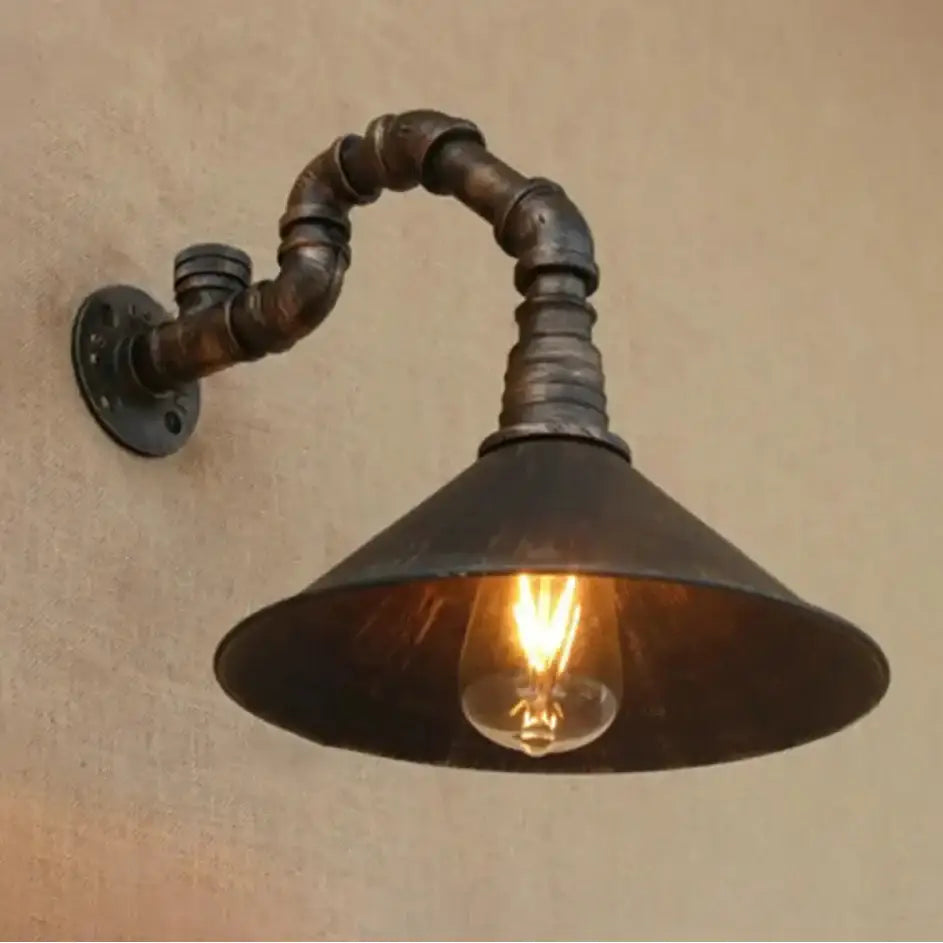Decorbites™ farmhouse style antique brass wall sconce with dark rustic metal pipe arm and antique brass cone shade