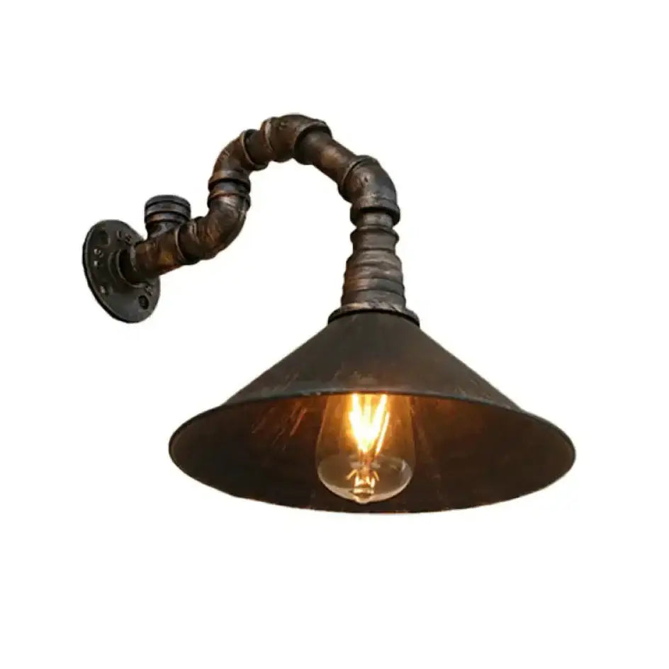 Decorbites™ farmhouse style antique brass wall sconce with rusted metal pipe arm and antique brass cone shade housing filament bulb