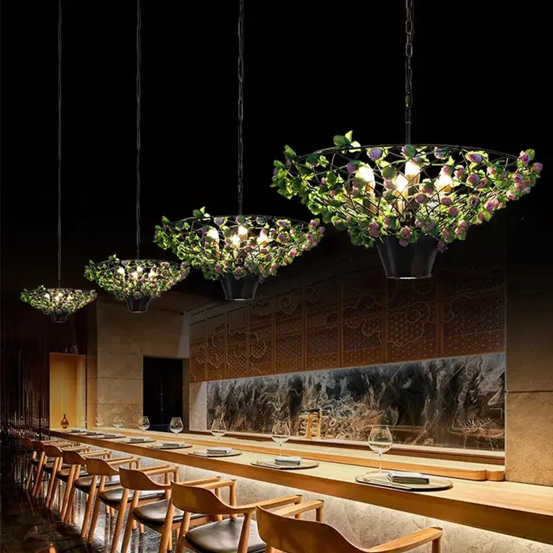 Elegant black metal pendant light with bronze leaf accents and greenery for industrial barbecue restaurant decorbites
