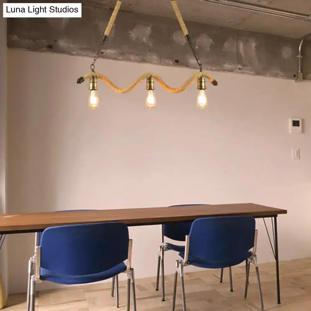 Industrial beige rope pendant light with three exposed bulbs suspended by braided rope and brass hardware for dining room