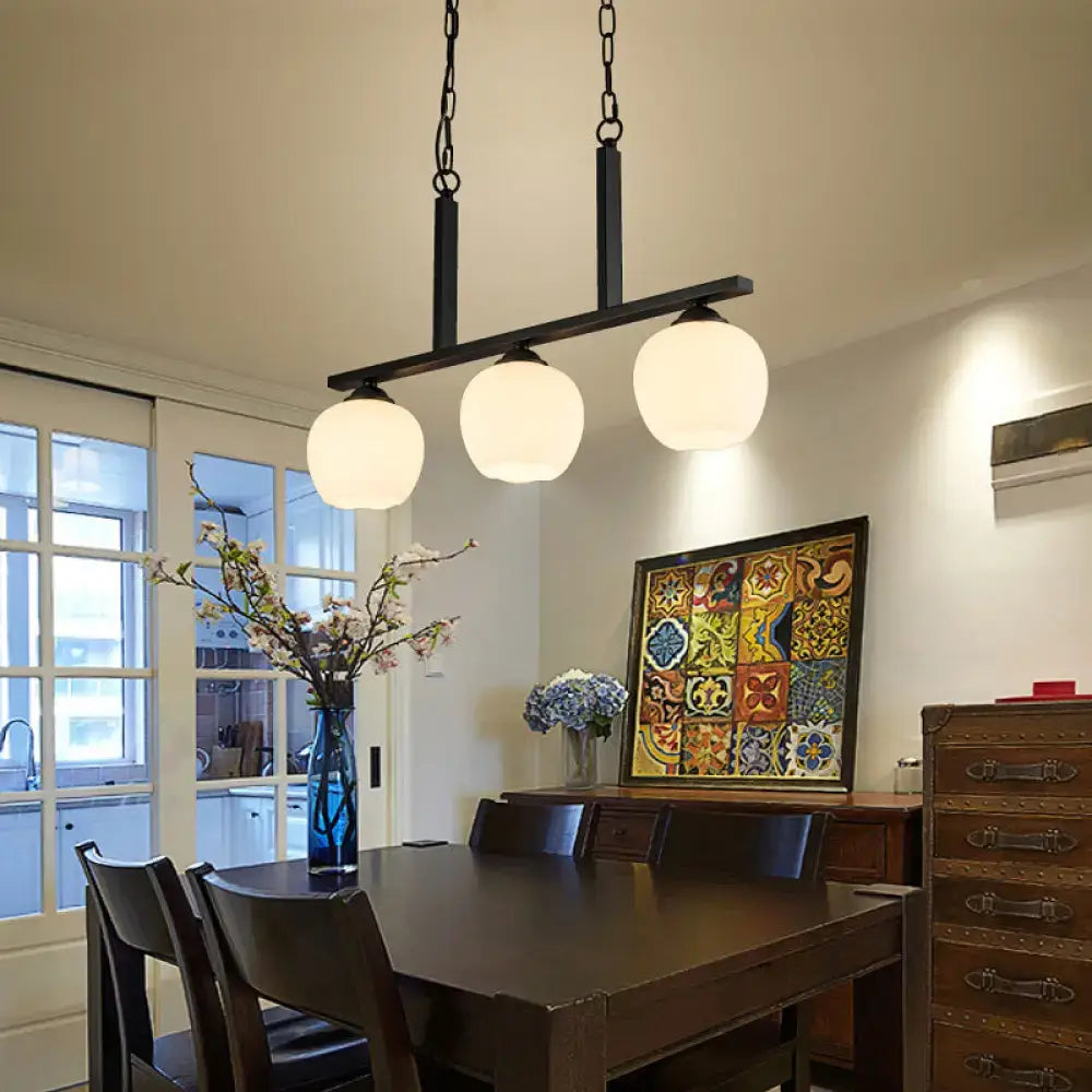 Black DecorBites™ industrial pendant light with three opal glass globe shades perfect for dining rooms