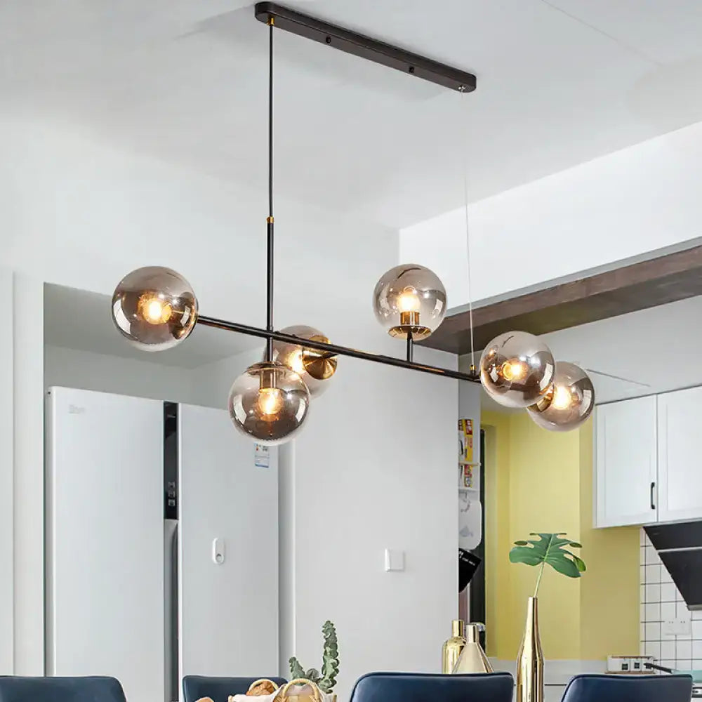 Modern black metal 6-light island pendant with five smoked glass globe shades in amber milky white gradient