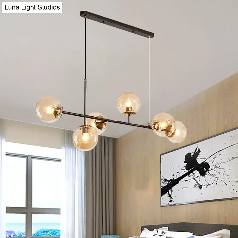 Modern black metal 6-light island pendant with five warm amber milky white glass globe bulbs and adjustable cord