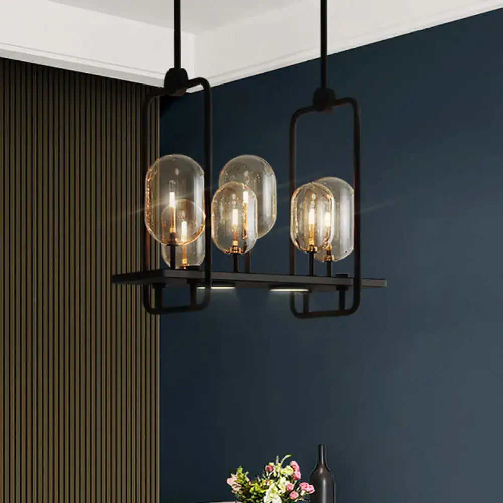 Black metal chandelier with four clear glass globes and warm amber glass filament bulbs, adjustable chain cord length and fixture height