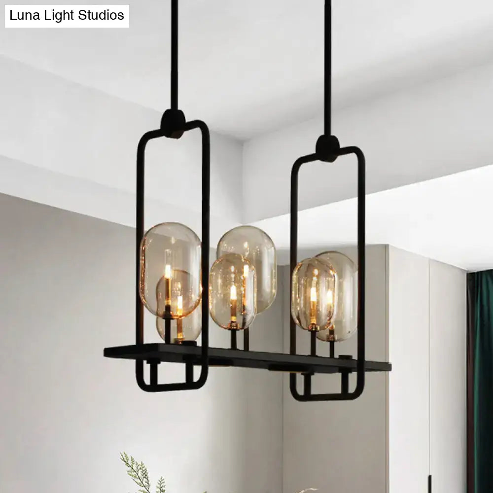 Black metal frame pendant light with three amber glass globe shades featuring adjustable chain cord length and fixture height