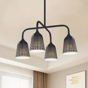 Black metal pendant light with four perforated lampshades and black bell bulb base for kitchen dinette island
