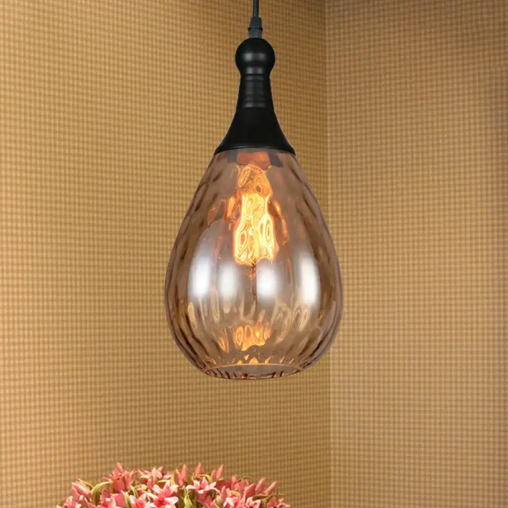 A teardrop-shaped amber glass ceiling light pendant with an industrial black brass top and exposed filament bulb